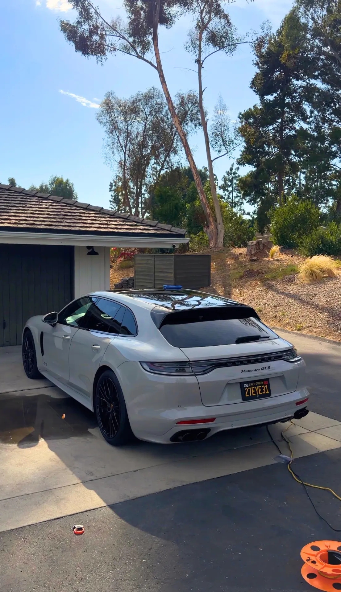 Freshly washed white Porsche Panamera in a driveway